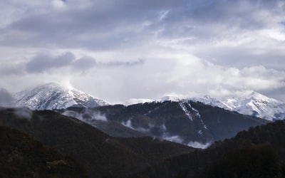 冰雪覆盖下的山在白天多云的天空
